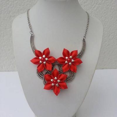 collier plastron en métal argenté avec fleurs de satin rouge